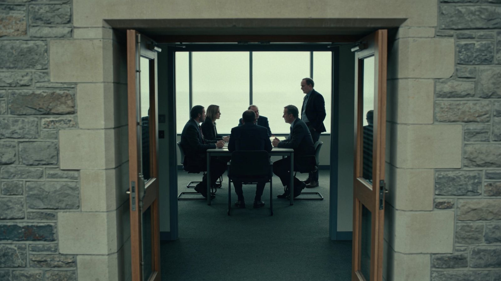 A meeting in progress seen through an open doorway