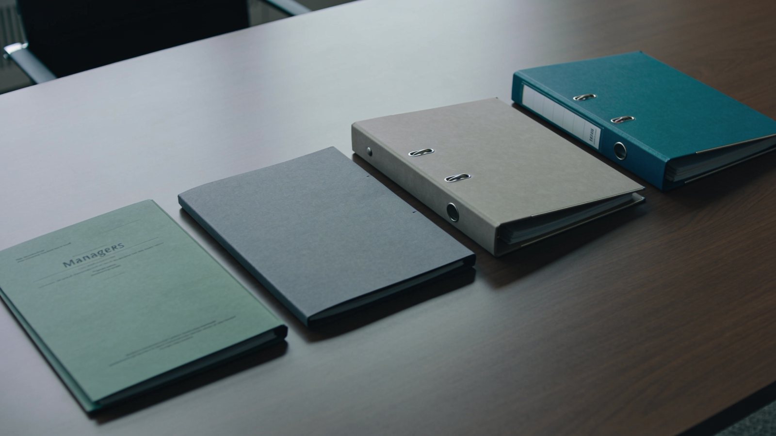 Four mismatched report folders laid out in a row